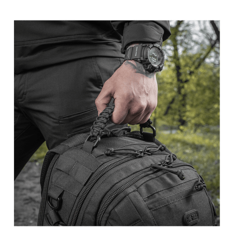Man holding M-Tac Mission Pack Elite backpack with MOLLE LASER CUT system, made of durable Cordura 1000D.