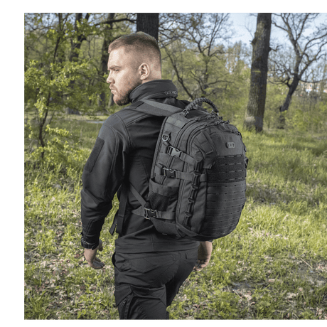 Man wearing M-Tac Mission Pack Elite backpack in nature, highlighting ergonomic design and durable Cordura 1000D material.