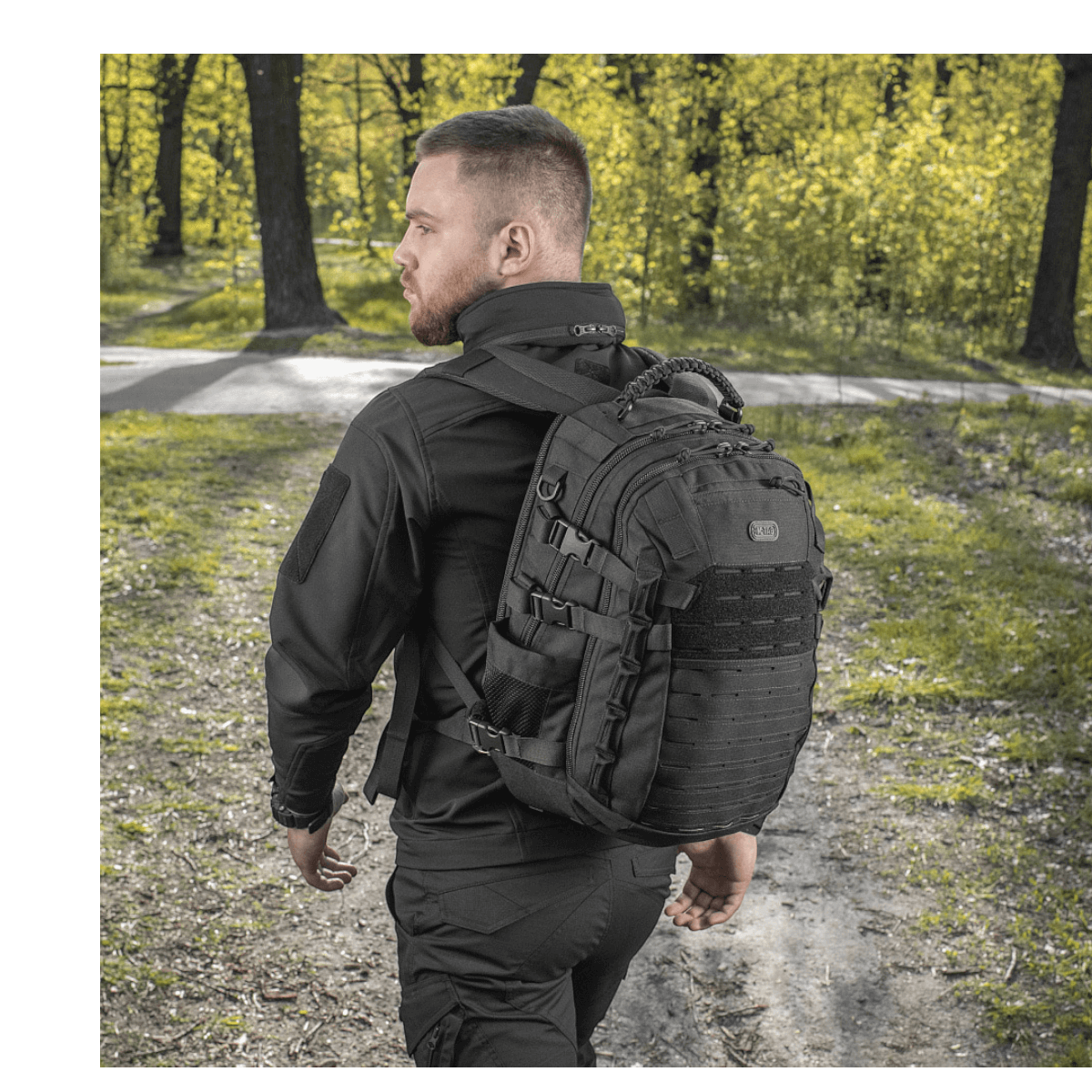 Mand bærer M-Tac Mission Pack Elite rygsæk med MOLLE LASER CUT-system i skov, slidstærk Cordura 1000D for holdbarhed.