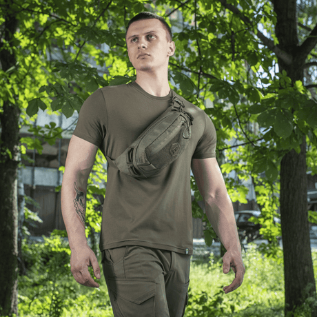 Man wearing M‑Tac Belt Bag Elite Hex in a natural environment, ideal for everyday use, with Cordura 500D and Woojin buckles.