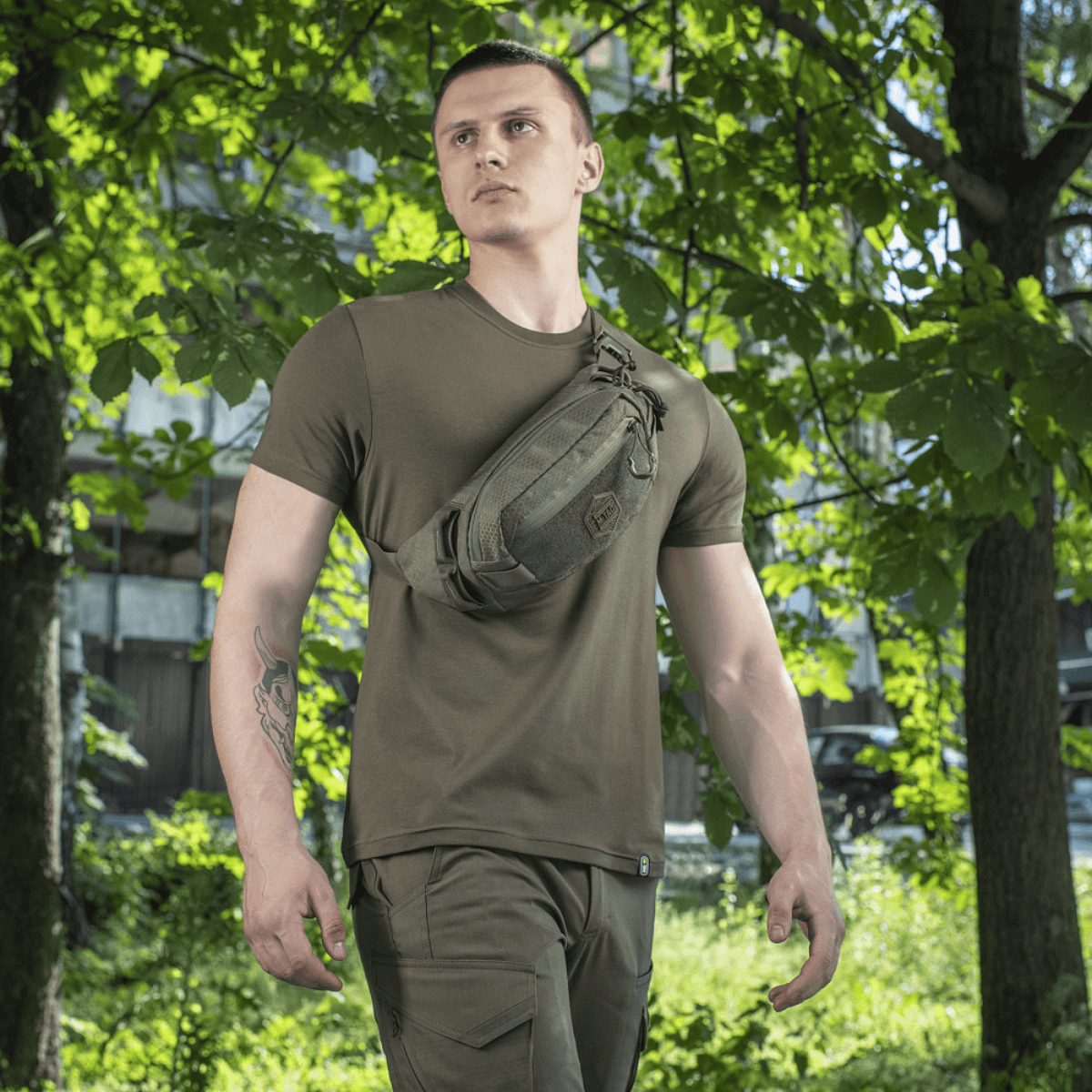 M-Tac Bæltetaske Elite Hex bæres af person i naturmiljø. Taske lavet af Cordura 500D med YKK lynlåse og Woojin spænder.