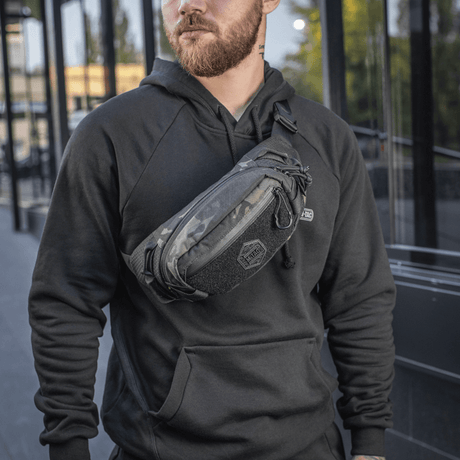 Man wearing M‑Tac Elite Hex belt bag in an urban setting, fashionable and functional with Cordura and YKK zippers, ideal for everyday use.