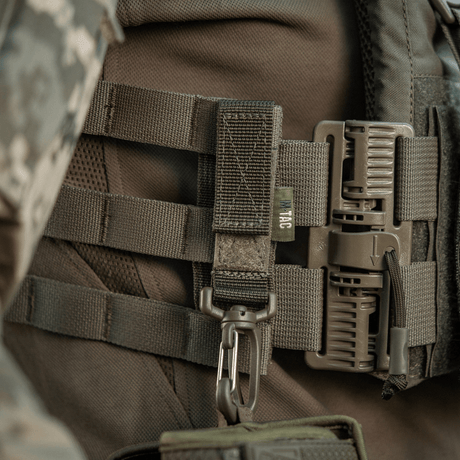 M-Tac Karabinhage Tilbehør fastgjort til MOLLE-system på taktik rygsæk for ekstra udstyr. Justerbar Velcro-rem for sikker fastgørelse.