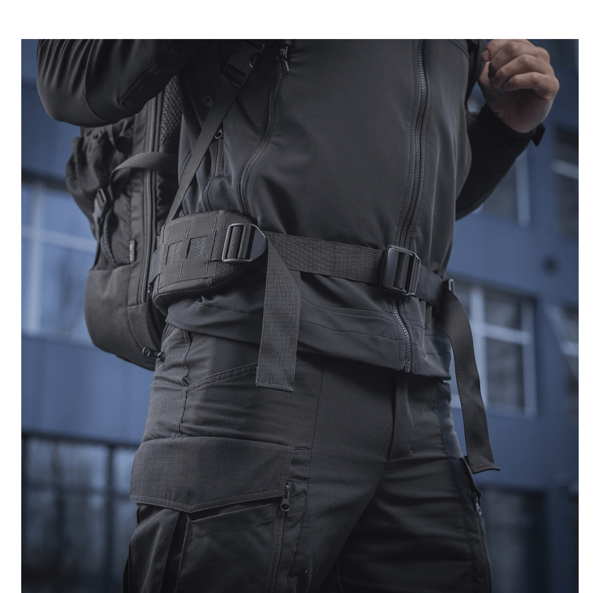 Person bærer M-Tac Rygsæk Large Elite Hex Gen. IV, en ergonomisk og stilfuld rygsæk lavet af slidstærkt Cordura-materiale.