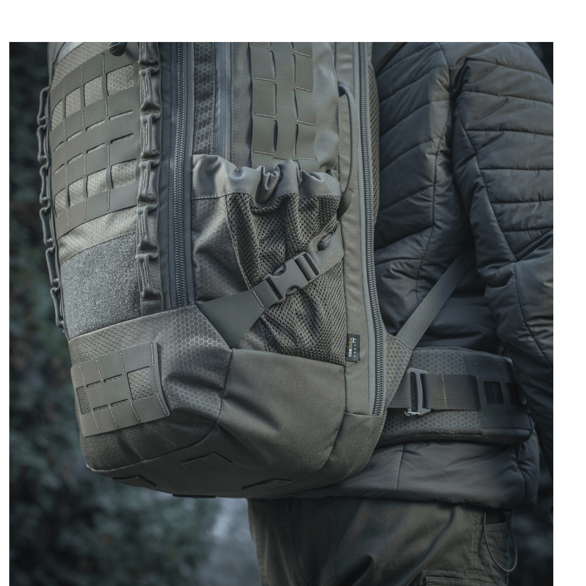 M-Tac Rygsæk Large Elite Hex Gen. IV i Cordura materiale set bagfra i udendørs miljø, ergonomisk designet til alsidig brug.