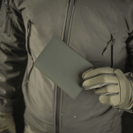 Person holding an M‑Tac passport cover, a stylish passport protector in polymer composite, ideal for Ukrainian and foreign passports.