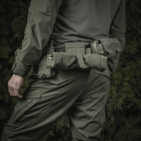 Man wearing tactical gear with M‑Tac magazine pouch Dump Pouch Lite Elite mounted on belt for magazine handling.
