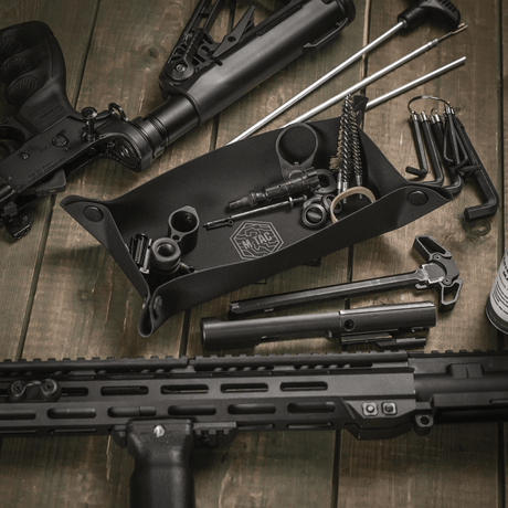 M‑Tac Field Maintenance Tray 18x30 cm on a training range with tools and weapon parts.