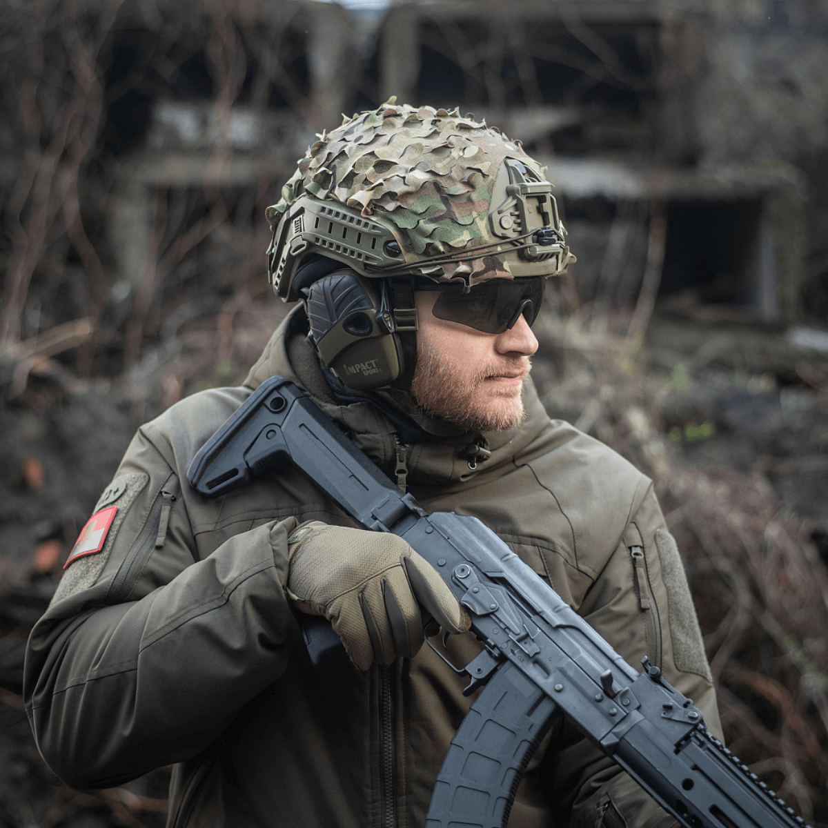 M‑Tac Vilha Hjelmdække FAST i Multicam mønster, bæret med camouflagehjelm og beskyttelsesudstyr i ujævnt terræn.