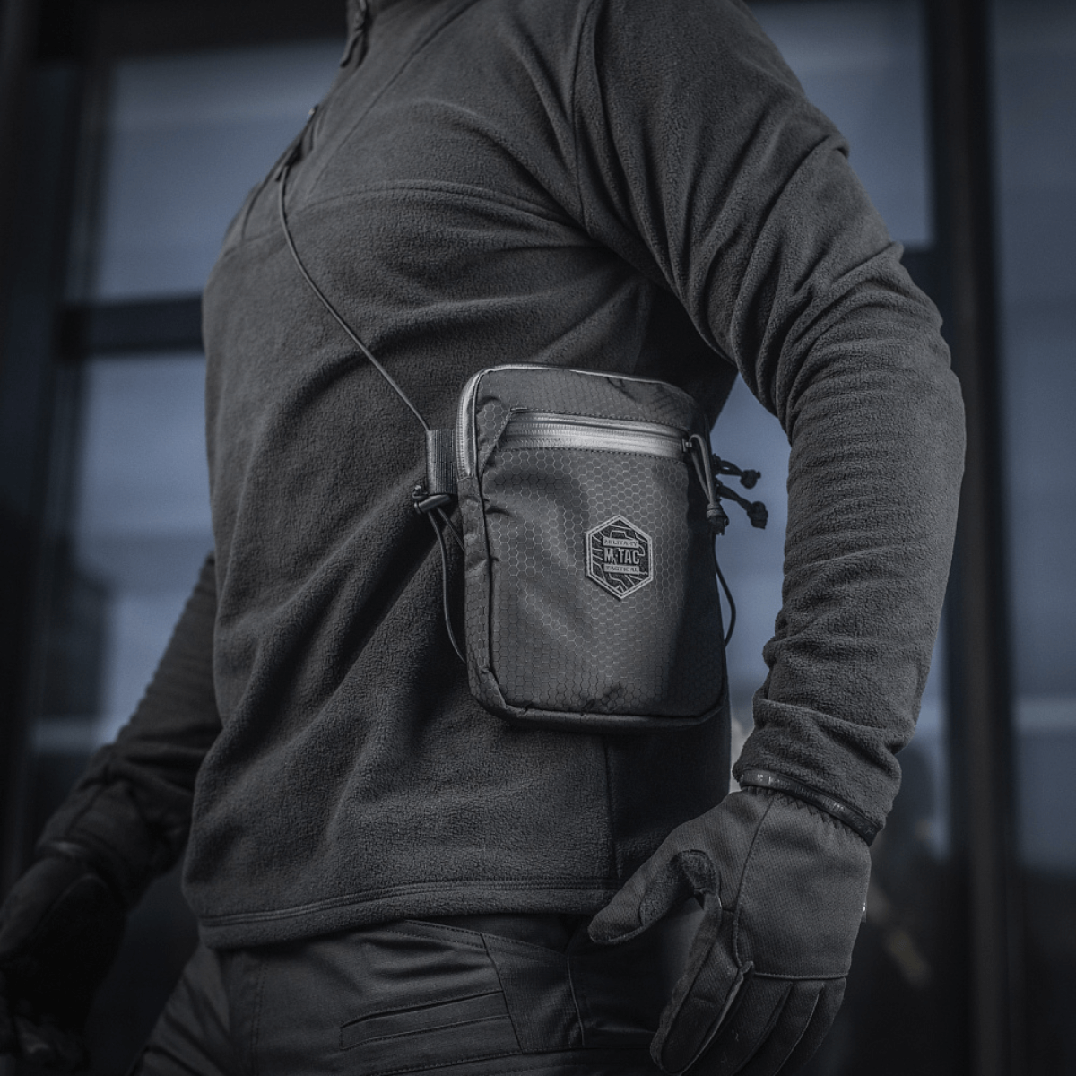 M‑Tac Pocket Bag Elite HEX båret af person, kompakt taske ideel til EDC-udstyr, nøgler og værktøj, holdbar kvalitetskonstruktion, sort design