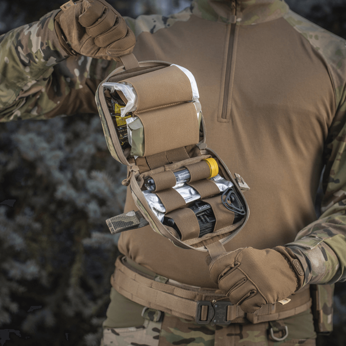 M-Tac Horisontal Medic Lomme Large Elite, robust førstehjælpssæt lavet af Cordura 500D, holdt af person i militærudstyr.