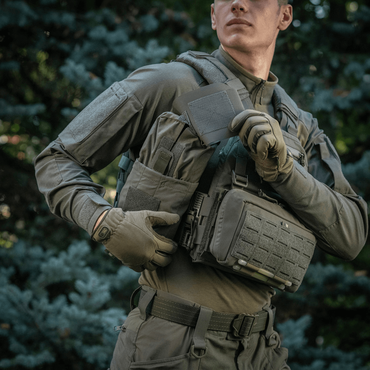 Mand bærer M‑Tac Medic Pouch Vertical Large Elite i felten med naturbaggrund.