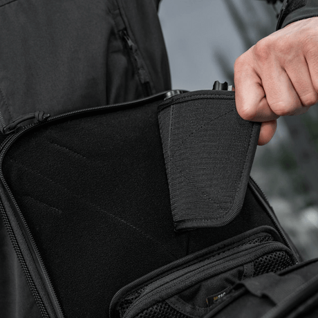 Person demonstrerer skjult våbenrum i M-Tac Tablet Bag Laser Cut Hex med modulære inserts og hurtig adgangsdesign.