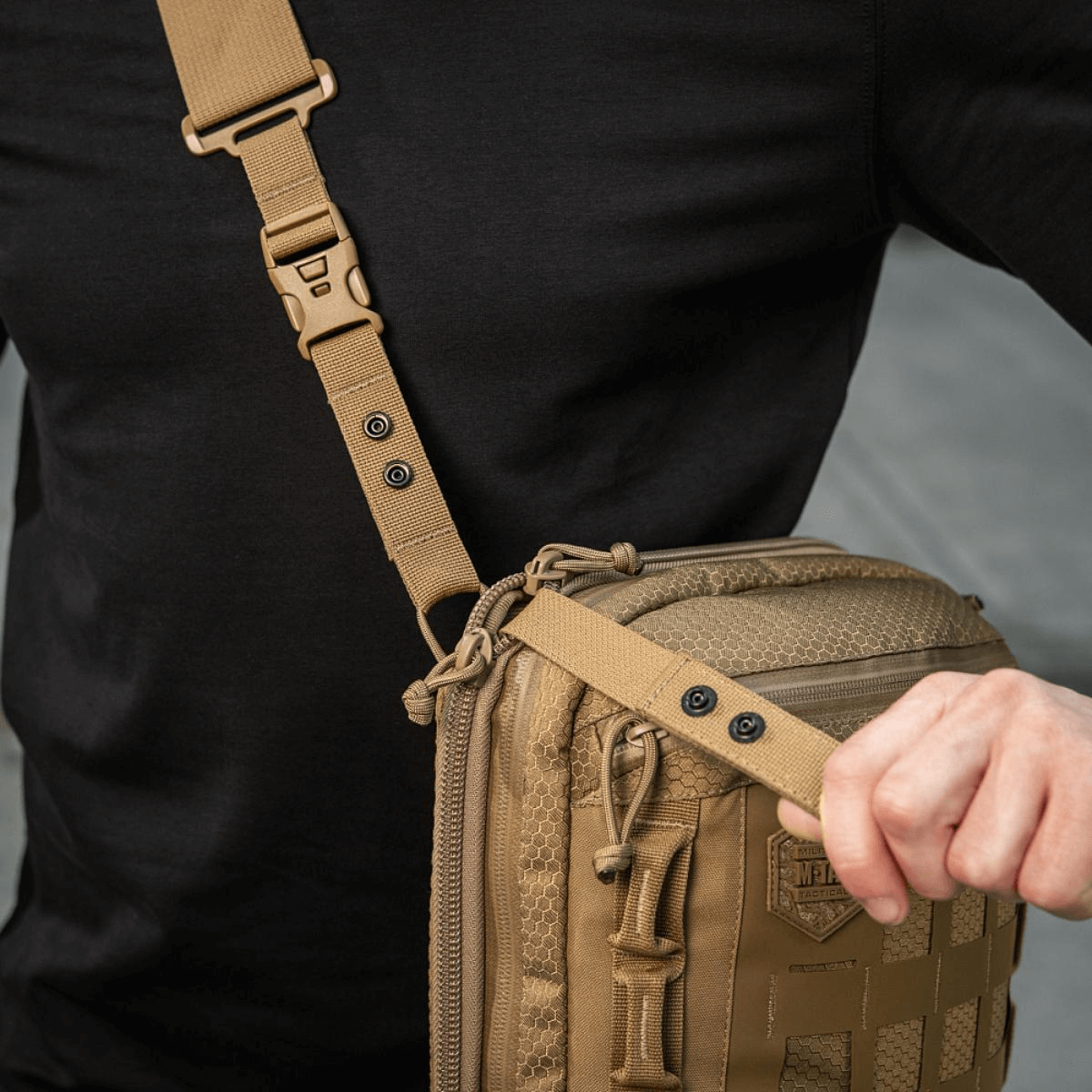 Person carrying M-Tac Tablet Bag Laser Cut Hex with MOLLE system and adjustable strap