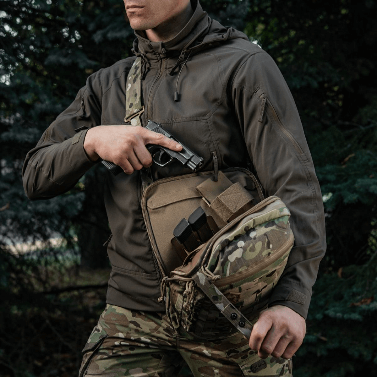 M-Tac Tablet Bag Laser Cut Hex i brug til skjult våben med hurtig adgang, camouflage design, mand iført taktisk tøj.