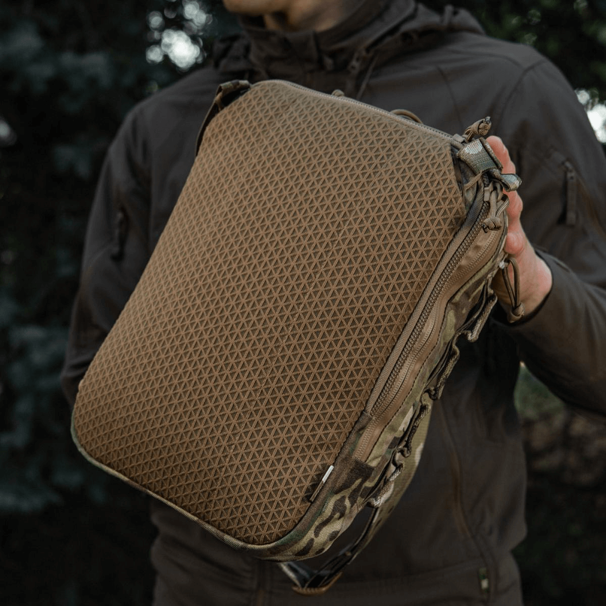 M-Tac Tablet Bag Laser Cut Hex med Cordura materiale og Laser Cut MOLLE, ideel til EDC og skjult våben, viste i udendørs miljø.