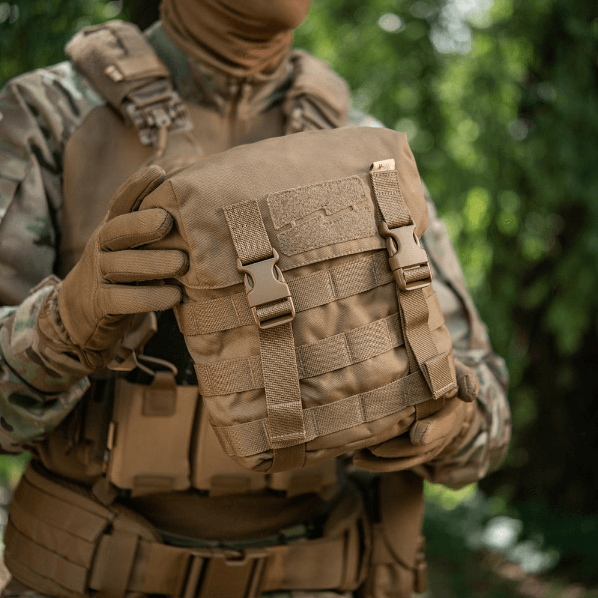 M-Tac Sukharka Gen.3 Pouch i Cordura 500D med MOLLE-interface holdt af en person i camouflagetøj i skovmiljø