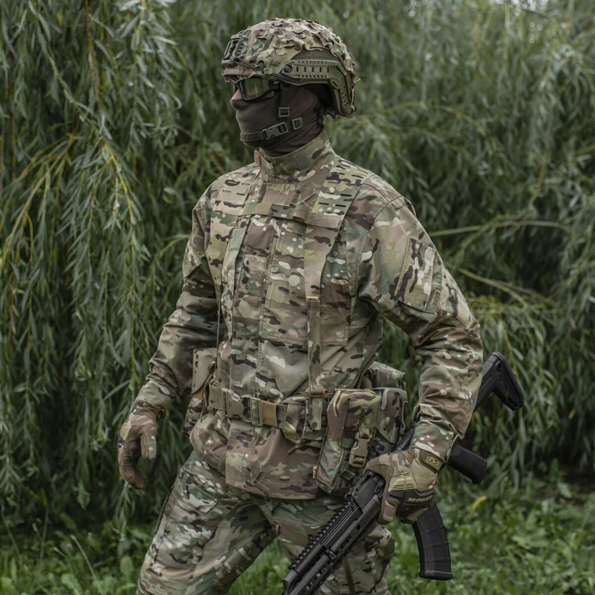 Soldat iført camouflageuniform med taktisk udstyr i naturen, klar til mission, bærer M-Tac Skulderstropper til taktisk bælte Laser Cut.