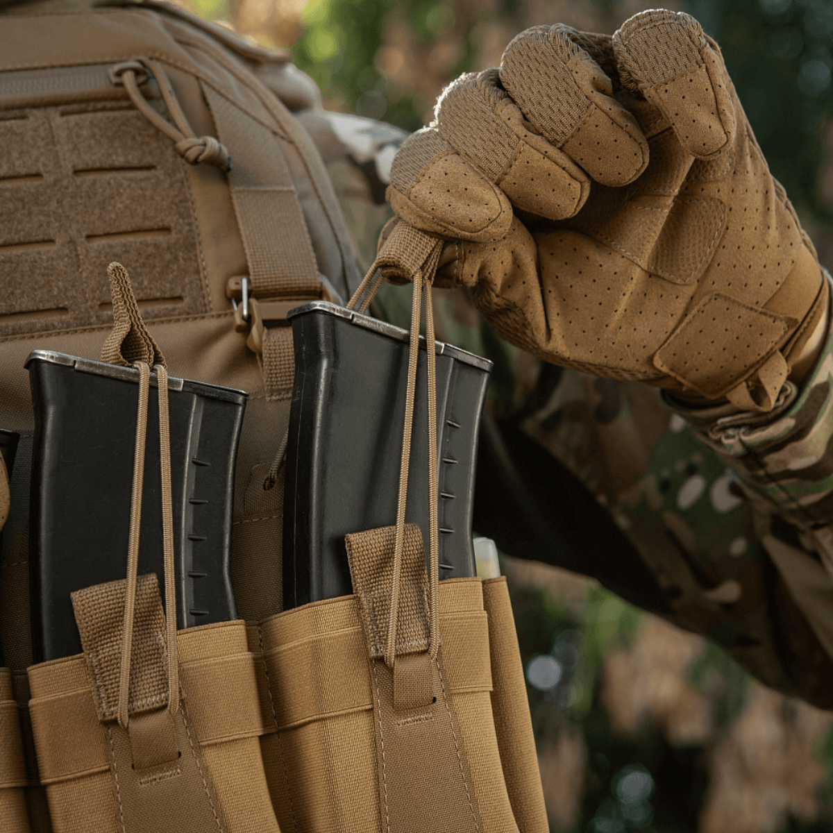 M-Tac Frontpanel til Plate Carrier Cuirass QRS til 4 Magasiner i brug, med soldat i camouflageuniform justerer magasinskift.