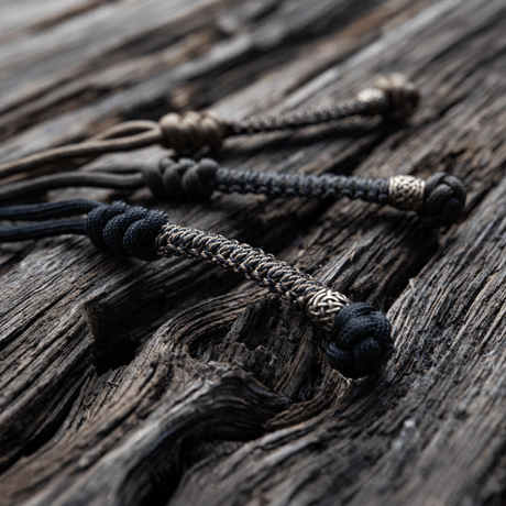 M-Tac Knife Lanyard Scandinavian braided paracord addition to pocket knives on a wood surface, stylish and practical accessory.