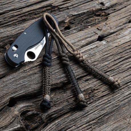 M-Tac Knife Lanyard Scandinavian stylish braided paracord for pocket knives on a wood surface.