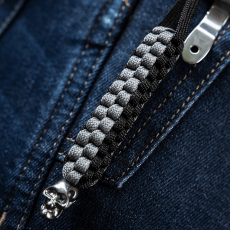 M-Tac Knife Lanyard Cuboid Skull with paracord and decorative skull bead on a zipper background, stylish and practical accessory.