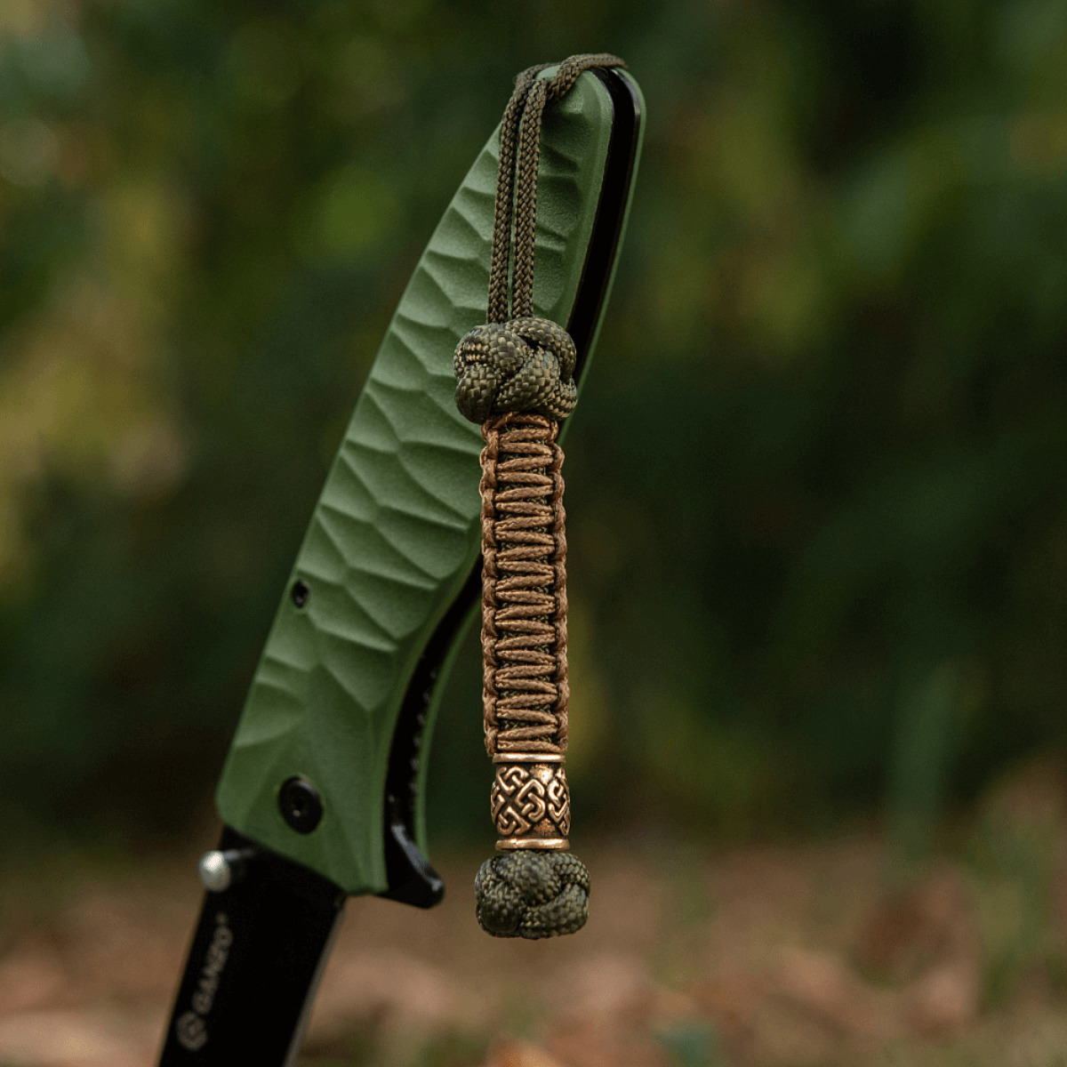 M-Tac Knife Lanyard Celtic flettet paracord knivtilbehør, der fremhæver personlig stil og praktisk anvendelse i udendørs- og hverdagsaktiviteter.