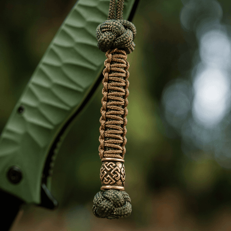 M-Tac Knife Lanyard Celtic in braided paracord with decorative Celtic pattern attached to the grip of a knife.