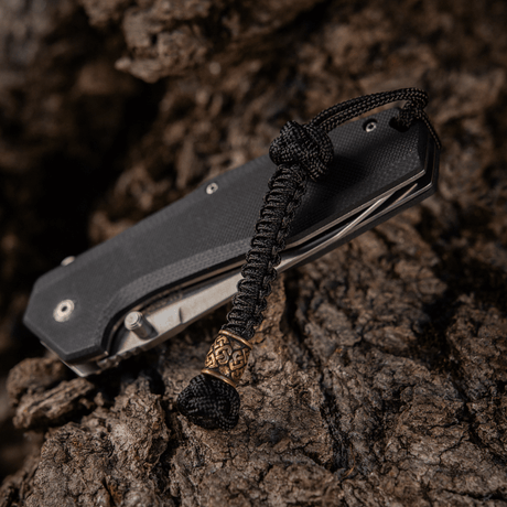 M-Tac Knife Lanyard Celtic braided paracord lanyard with Celtic design on a black knife, stylish accessory for knives and gear.