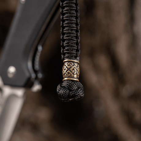 M-Tac Knife Lanyard Celtic in braided paracord with decorative pattern, shown on a knife as a stylish and practical accessory.