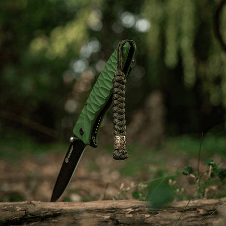 M-Tac Viper Lanyard Scandinavian in braided paracord with Viper bead by a pocket knife in nature, a stylish accessory.