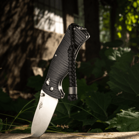 M-Tac Viper Lanyard Stainless Steel on knife for stylish, practical retrieval in a forest setting.
