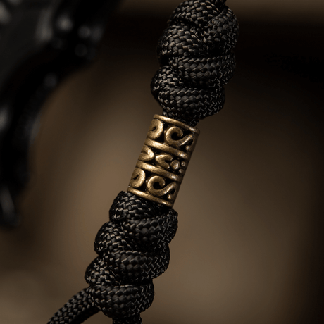 Detailed image of M-Tac Zeus Lanyard with braided paracord and decorative brass piece, suitable for knife and gear.