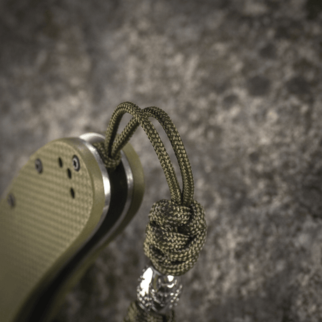 M-Tac Zeus Stainless Steel Lanyard with braided paracord and decorative bead, attached to knife for flexible access and durability.