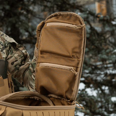 M-Tac Sturm Elite Gen.II with opened suitcase-style compartment and two mesh pockets for EDC gear outdoors in a forest setting.