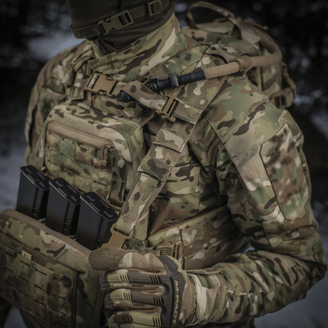 Soldier wearing M-Tac Sturm Elite Gen.II in camouflage clothing. Backpack with MOLLE system and built-in hydration system.