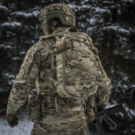 Soldier wearing M-Tac Sturm Elite Gen.II in snowy forest with MOLLE Laser Cut system and bungee cord for gear.