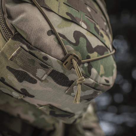 Close-up of M-Tac Sturm Elite Gen.II with camouflage pattern and bungee cord for outdoor gear.