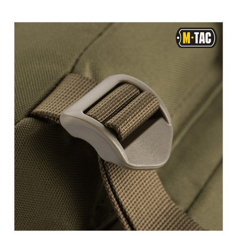 Close-up of M-Tac Assault Pack with adjustable shoulder strap and MOLLE attachment system in olive green