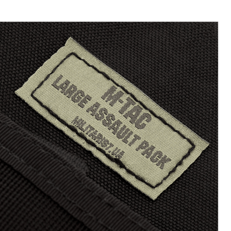 Label on M-Tac Large Assault Pack backpack close-up showing product logo and name text