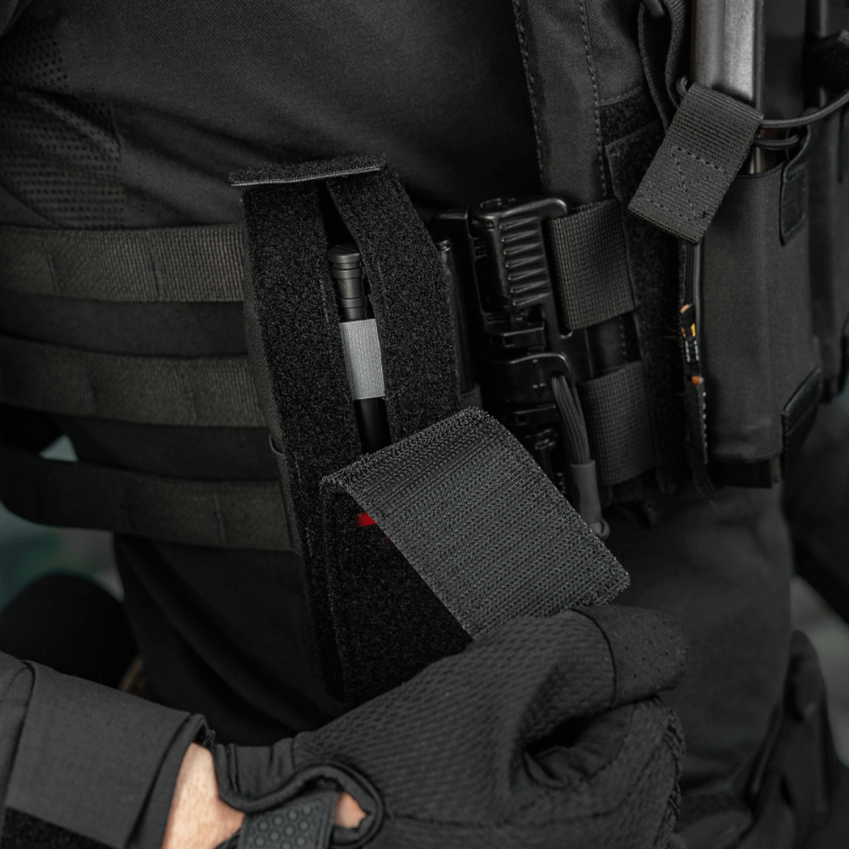 Person iført M-Tac Lomme til Tourniquet Closed på taktisk vest, klar til nødsituationer med tourniquet i sikker beskyttet lomme.