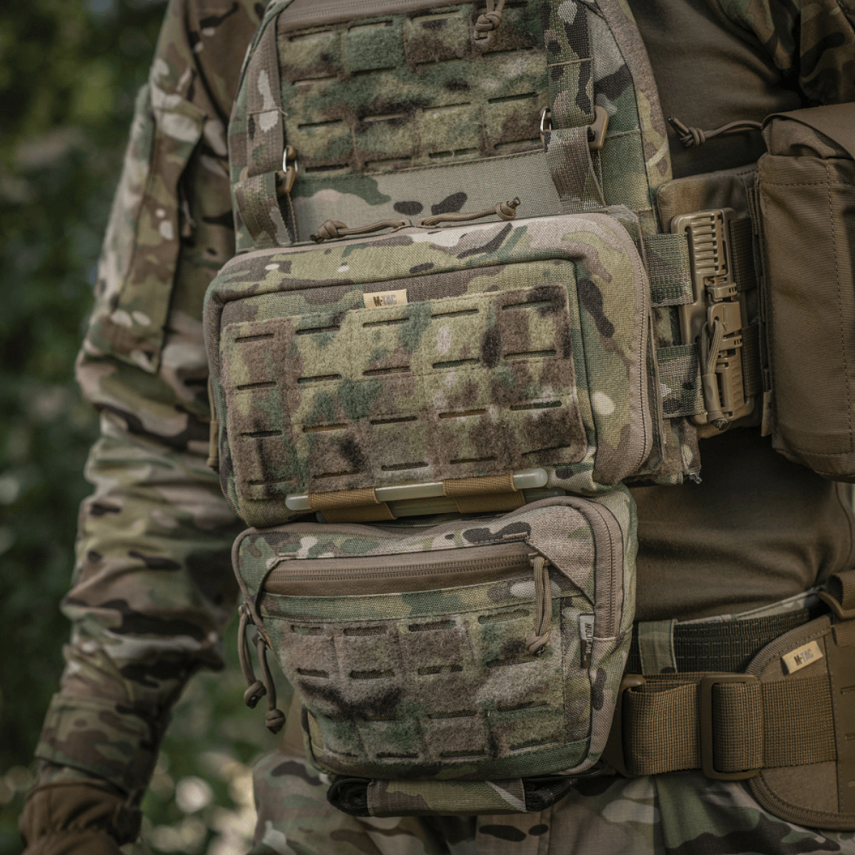 M-Tac Admin Pouch Large Elite monteret på camouflageudstyr, praktisk til opbevaring af taktiske genstande som dokumenter og nøgler.