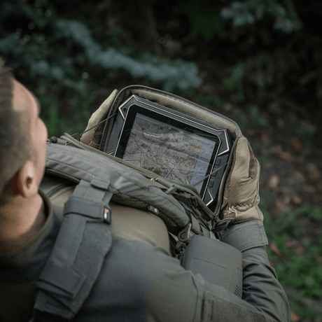 Person with M-Tac Admin Pouch Large Elite holding a tablet in a forest.