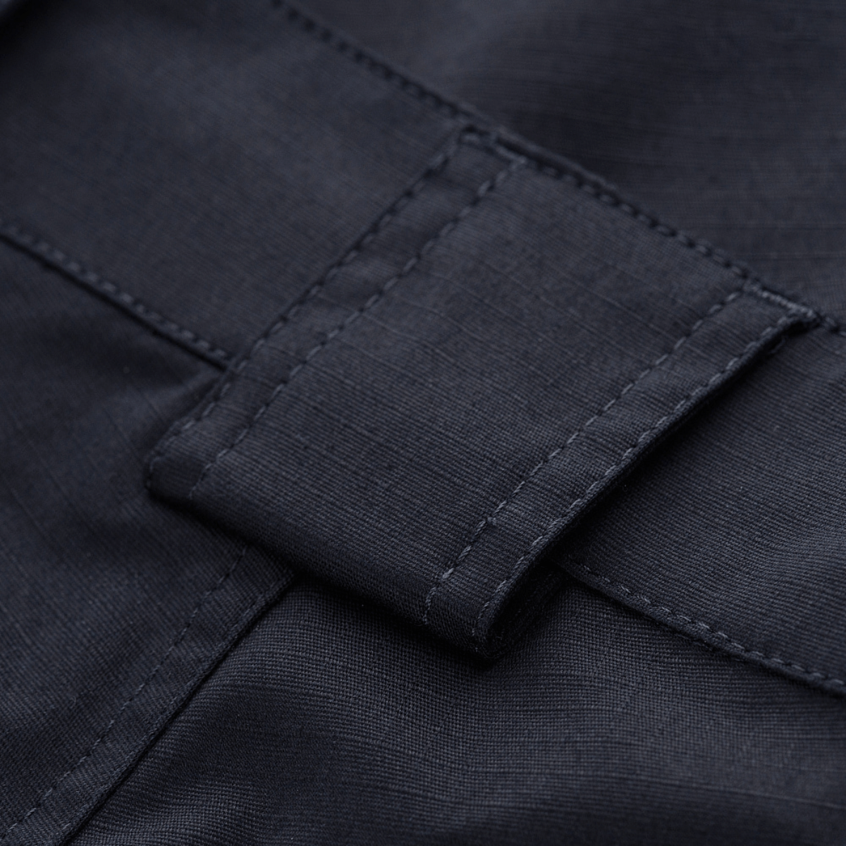 Nærbillede af rip-stop materiale på M-Tac Shorts Aggressor Gen.II Flex med Teflon-belægning, der er vand- og smudsafvisende.