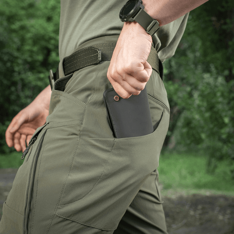 M-Tac Shorts Rubicon Flex i mørk oliven, viser en mand der bruger cargolommer, perfekt til sommer, behagelig og funktionel.