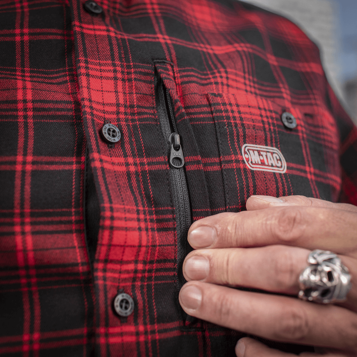 Nærbillede af M-Tac Redneck Skjorte i rød-svart ternet mønster, med lynlåsdetalje og M-Tac mærke, ideel til arbejde og fri.