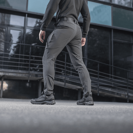 En person iført M-Tac Bukser Rubicon Flex, perfekt til træning og arbejde, i et moderne bymiljø. Komfortabelt 4-Way Stretch stof.