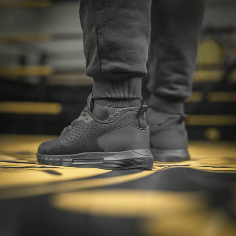 M-Tac Cotton Classic black shoes on a yellow fitness mat, designed for sport and everyday use with optimal comfort and freedom of movement.