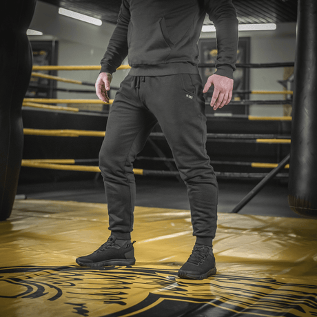 Man wearing M-Tac Cotton Classic pants in a gym, highlighting versatile sports pants with comfort and style.