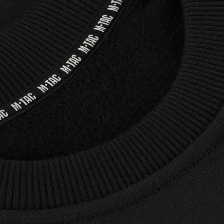 Detalje af M-Tac Sweatshirt Cotton Hard viser ribkant og reflekterende logo på sort 100% bomuldsmateriale, 390 g/m² tæthed.